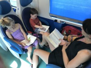 Joy and kids reading books on train