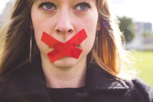 woman with red tape over mouth