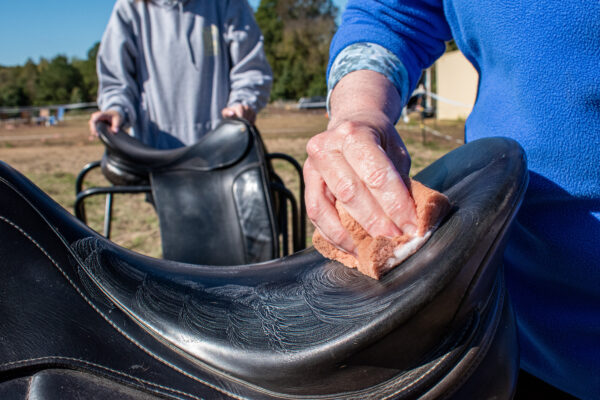 Volunteers helping to clean saddles at CORRAL Fall on the Farm!