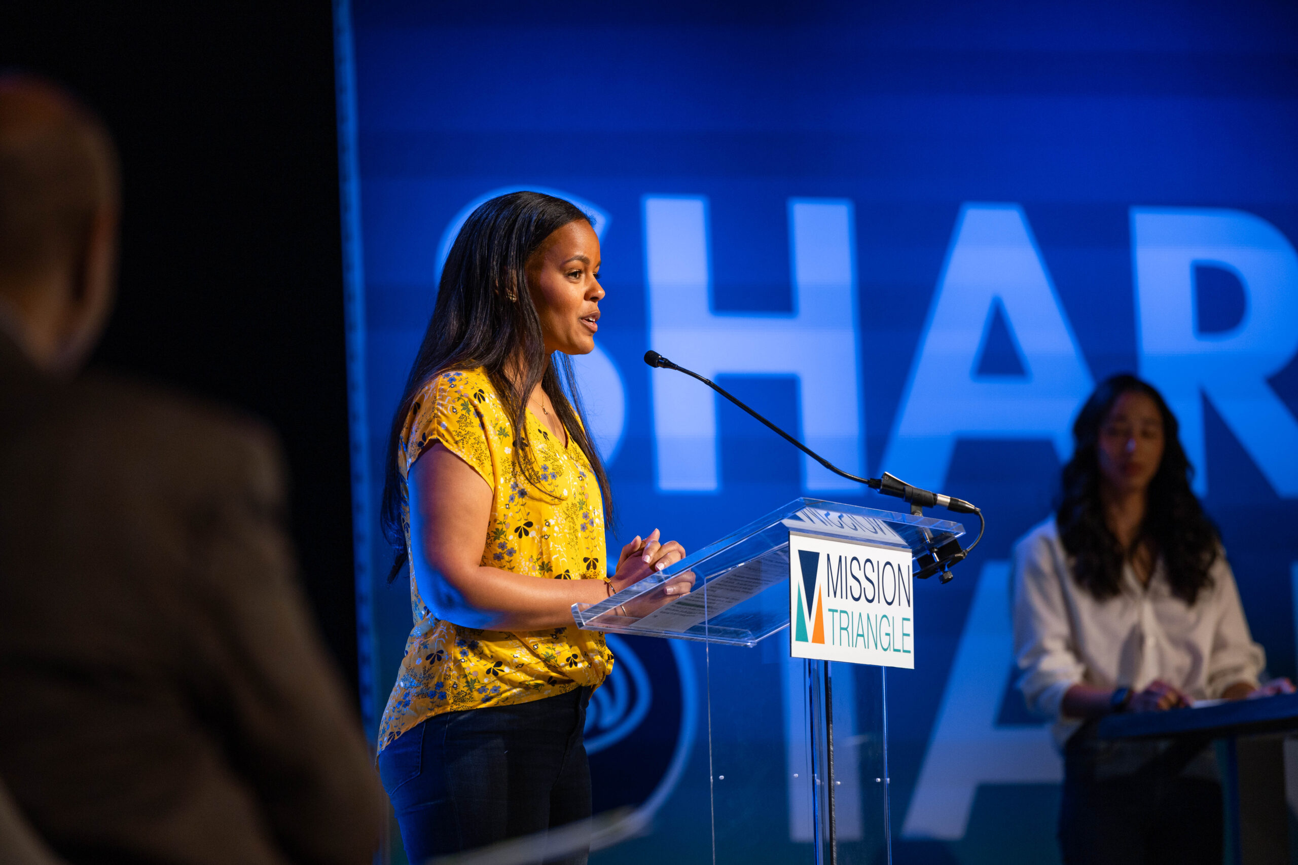 Lauren at a podium presenting at Mission Triangle's Shark Tank